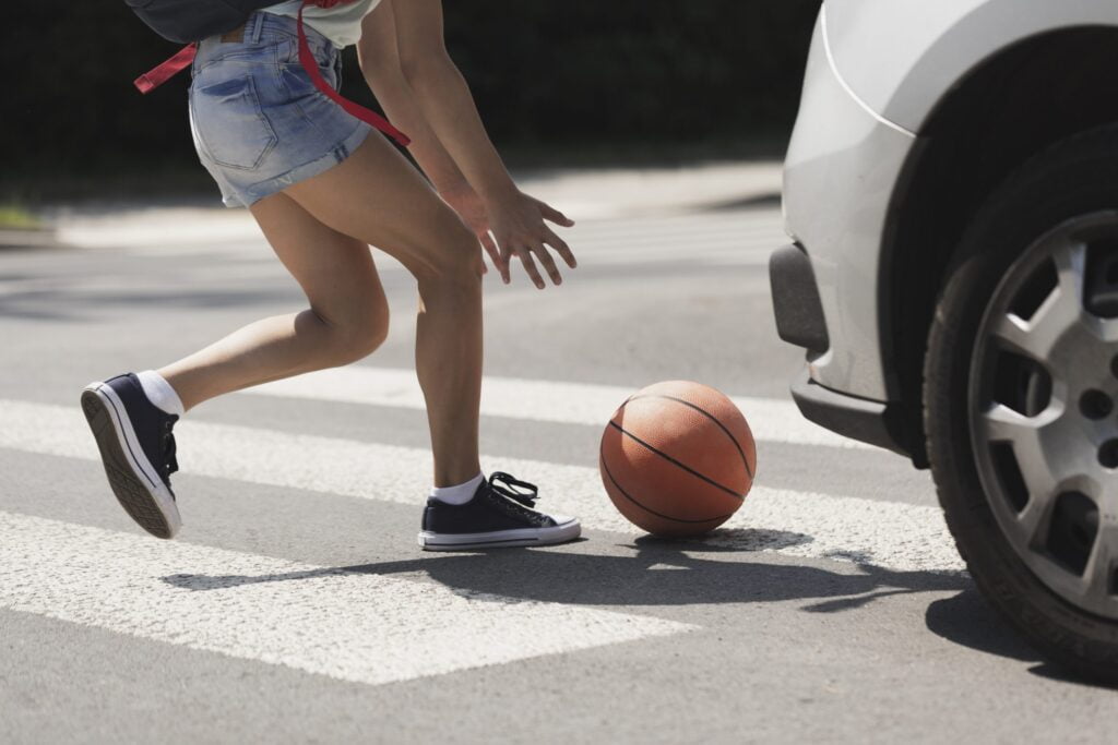 child running after basketball in the street