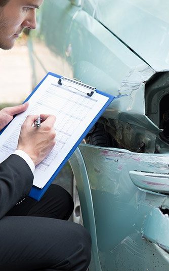 Car insurance adjuster inspecting damage